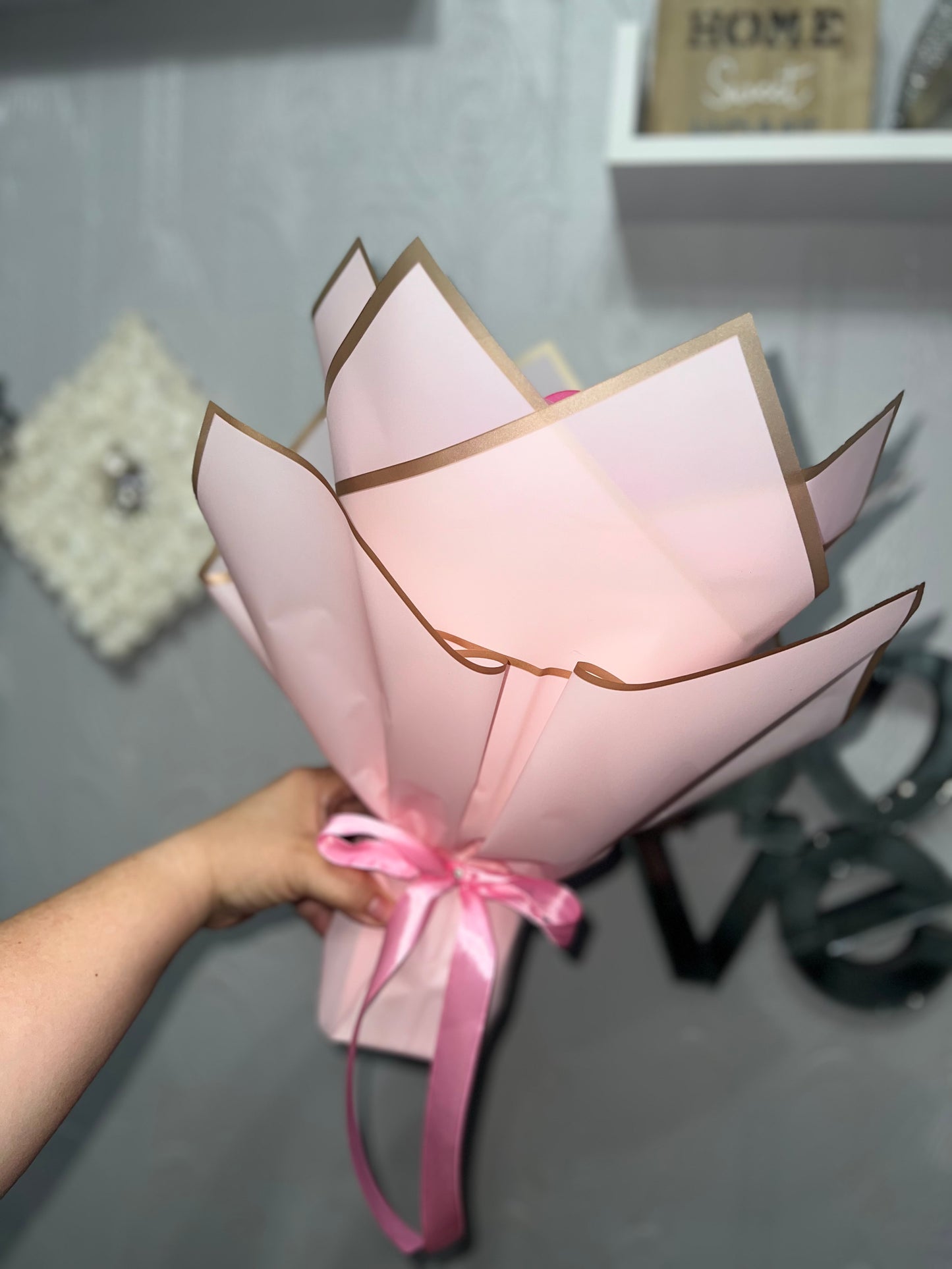Pink rose bouquet with gold foiled wrapper and holographic butterflies.