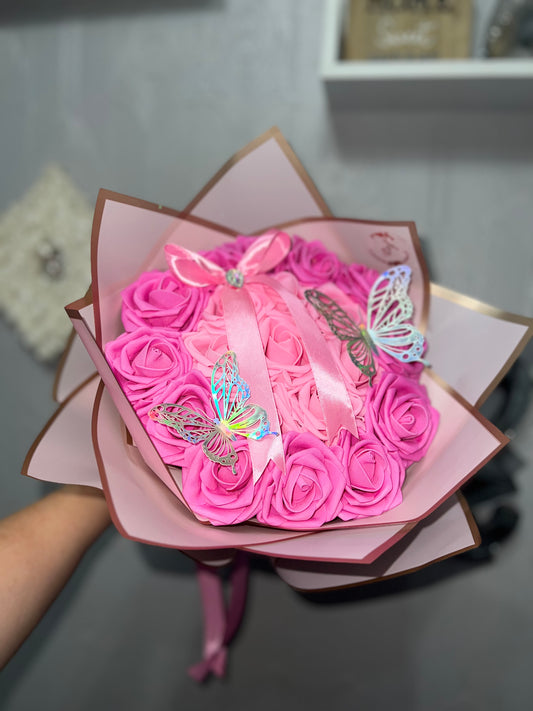 Pink rose bouquet with gold foiled wrapper and holographic butterflies.